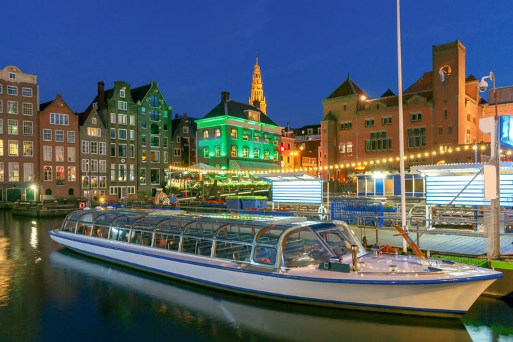 Večerní plavba lodí po kanále v Amsterdamu